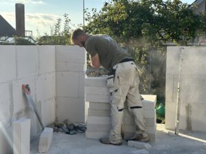 Murer der skærer gasbeton til at bygge ny tilbygning.