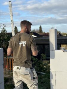 Murer der arbejder og er ved at måle op til næste gasbeton klods.